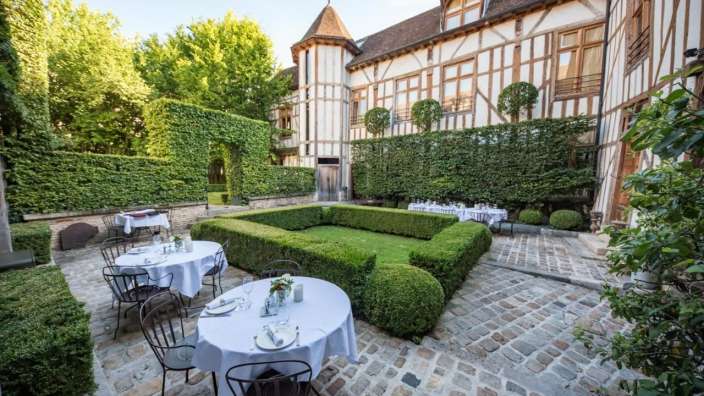 Eine Terrasse mit Tischen und Stühlen vor einem großen Gebäude