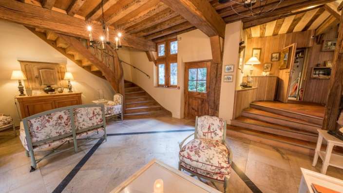 Ein Wohnzimmer mit vielen Möbeln und einer Treppe