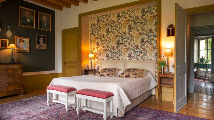 Ein Schlafzimmer mit einem Bett und zwei Hockern