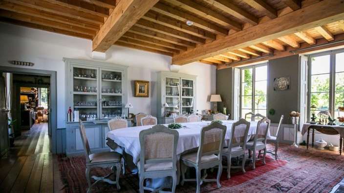 Ein Esszimmer mit einem langen Tisch und Stühlen