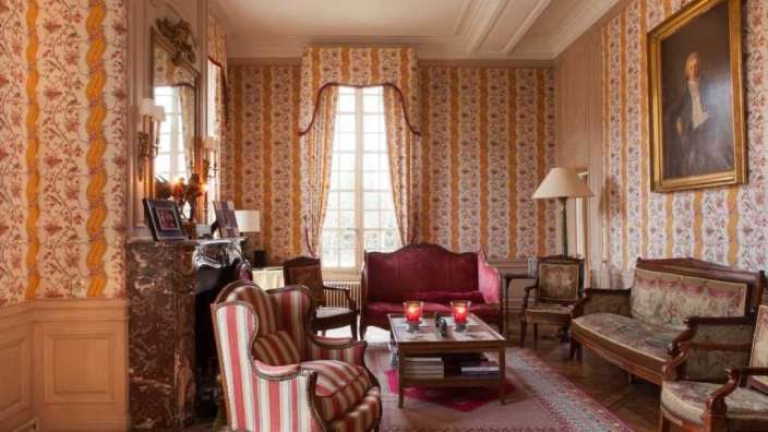 Ein Wohnzimmer mit gestreiften Wänden und Möbeln