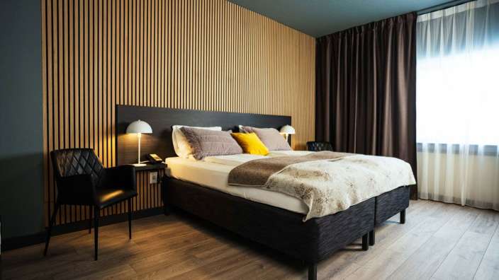 Ein Hotelzimmer mit einem Bett und zwei Stühlen