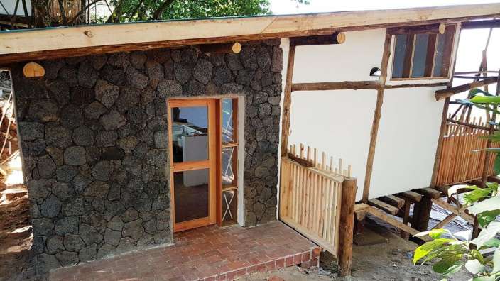 Ein Haus mit einer Steinmauer und einer Holztür