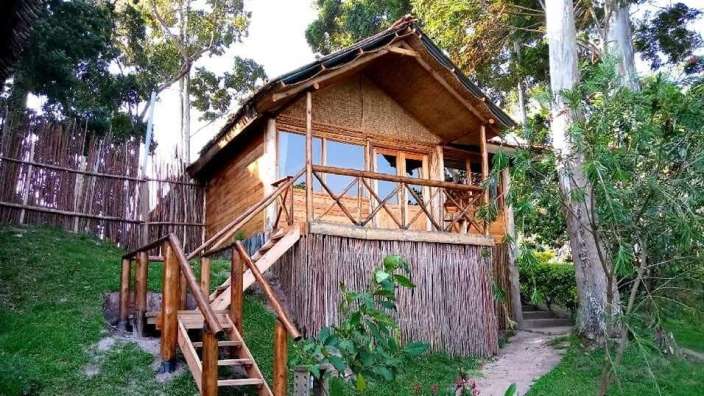 Ein kleines Holzhaus mit einer Treppe, die zu einem Balkon führt .