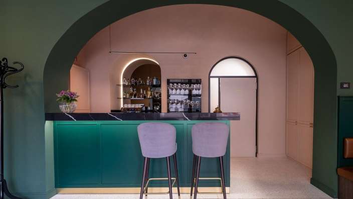 Eine Bar mit einem grünen Tisch und rosa Stühlen