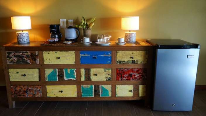 Ein kleiner Kühlschrank steht neben einer Kommode mit bunten Schubladen