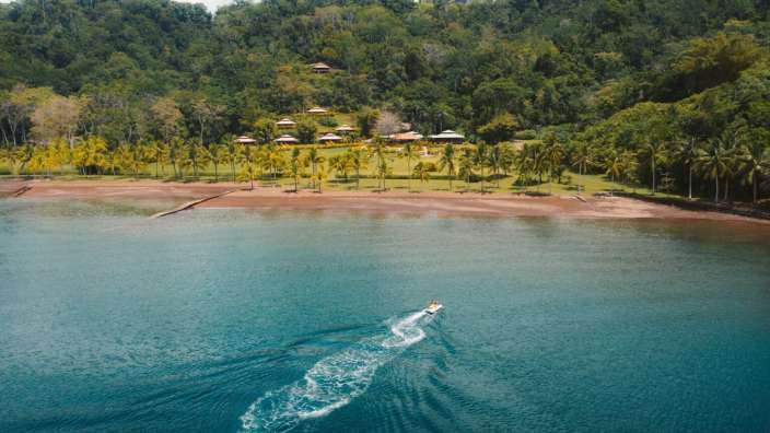 Ein Boot fährt an einem Strand vorbei