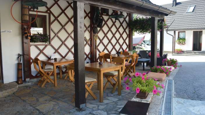 Ein Tisch und Stühle auf einer Terrasse mit einem Schild darüber