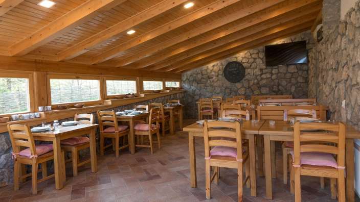Tische und Stühle in einem Restaurant mit einer Uhr an der Wand