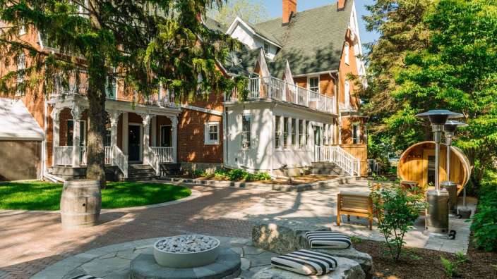 Ein großes Backsteinhaus mit einem Kamin und einer Sauna davor