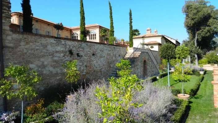 Ein Garten mit einem Steingebäude im Hintergrund