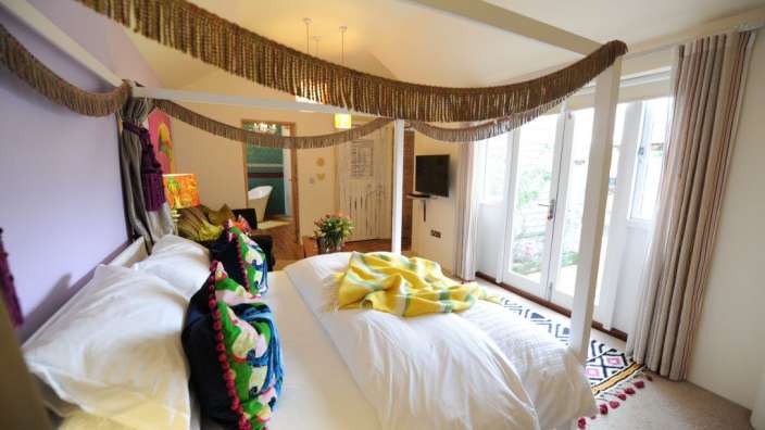 Ein Schlafzimmer mit einem Himmelbett und vielen Kissen