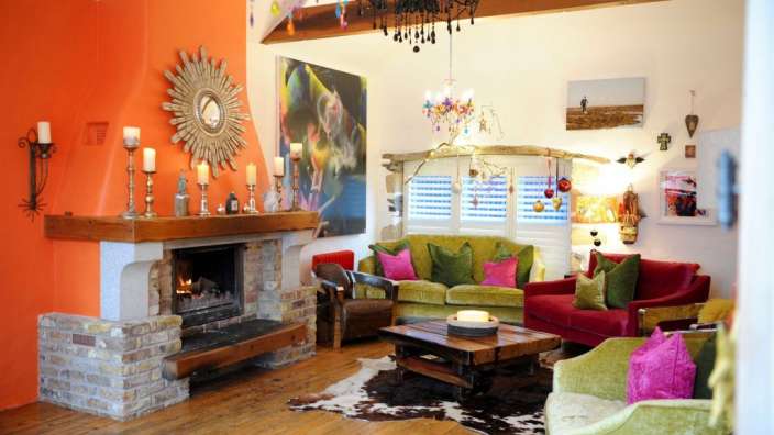 Ein Wohnzimmer mit orangefarbenen Wänden und einem Kamin