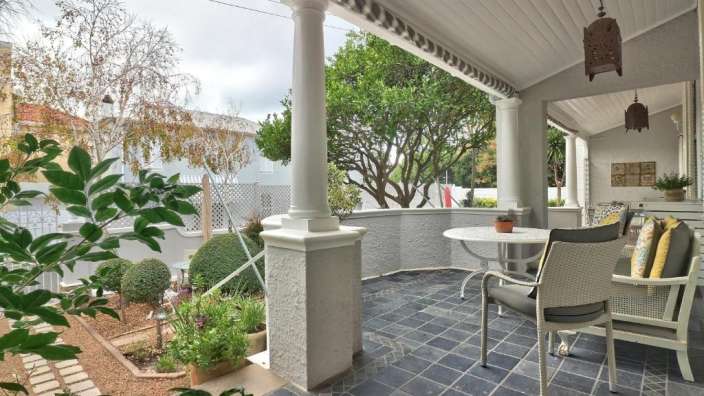 Eine veranda mit einem tisch und stühlen und einer hängelampe