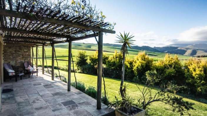 Eine Person sitzt auf einer Veranda mit Blick auf die Berge