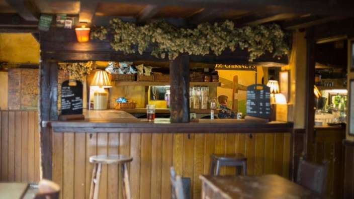 Eine hölzerne Bar mit einem Schild an der Wand, das zeigt, dass es afternoon tea gibt