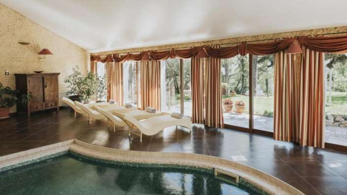 Ein großer Raum mit einem Swimmingpool und Liegestühlen