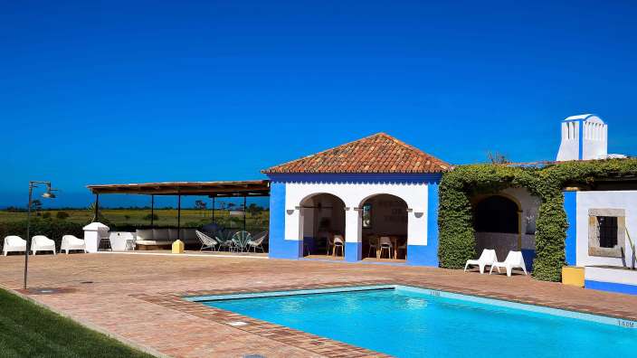 Ein großer Swimmingpool neben einem blauen und weißen Gebäude