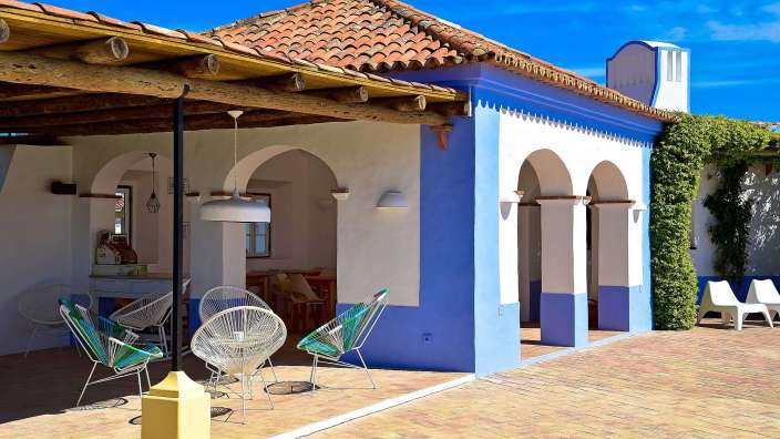 Ein blau-weißes Haus mit einem roten Ziegeldach