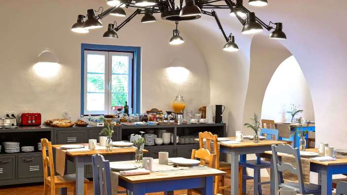 Ein Esszimmer mit Tischen und Stühlen und einem Kronleuchter