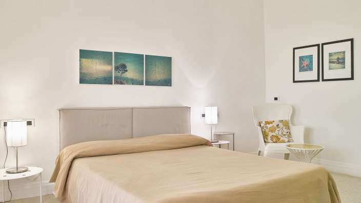 Ein Schlafzimmer mit einem Bett und drei Bildern an der Wand