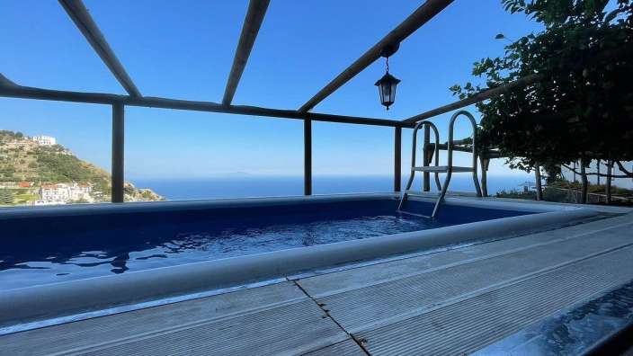 Ein großer Pool mit einer Treppe und einem Blick auf den Ozean