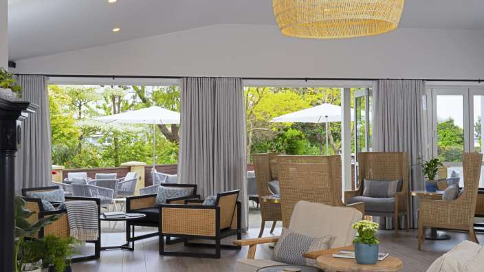 Ein Wohnzimmer mit vielen Stühlen und einem Tisch
