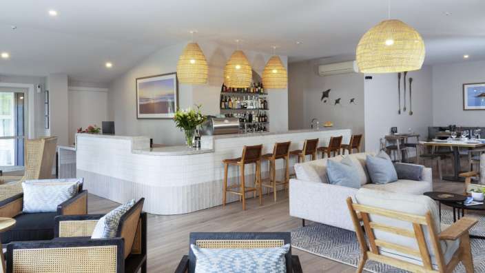 Ein Wohnzimmer mit Couch und Stühlen und einer Bar