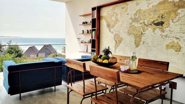 Ein Esszimmer mit einem Tisch und Stühlen und einer Weltkarte an der Wand