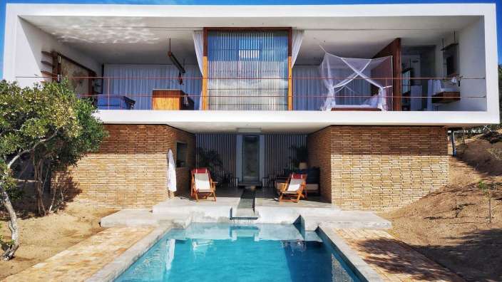 Ein großes weißes Haus mit einem Pool im Vordergrund