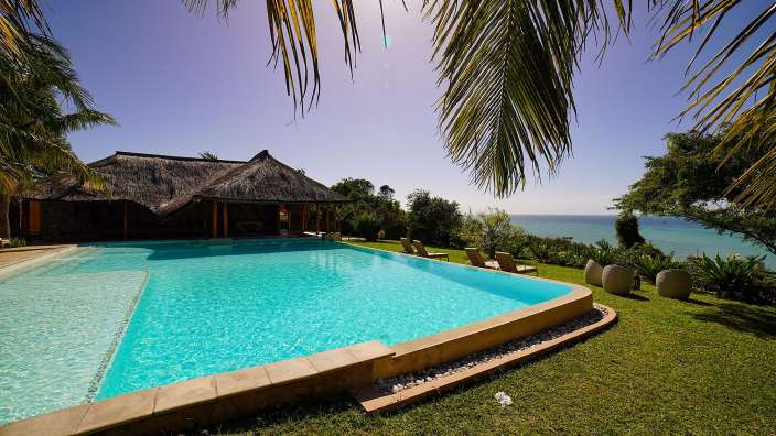 Ein riesiger Swimmingpool mit Palmen im Hintergrund