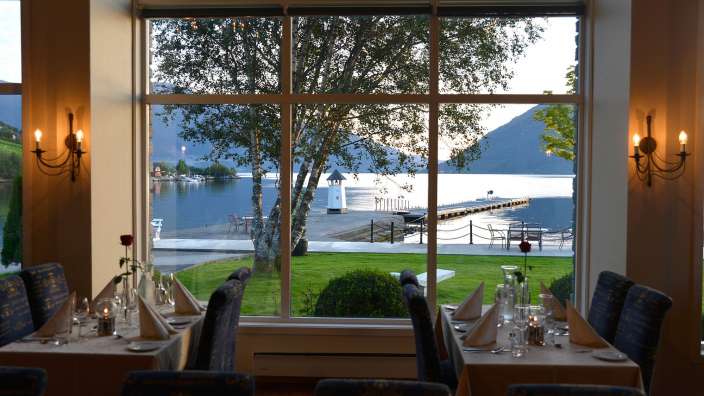 Tische und Stühle in einem Restaurant mit Blick auf einen See