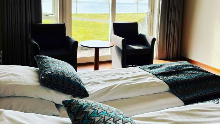 Ein Hotelzimmer mit einem Bett und zwei Stühlen