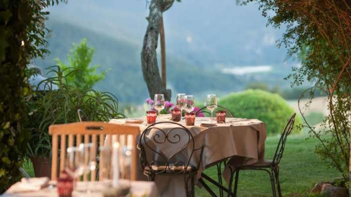 Ein Tisch und Stühle auf einer Terrasse mit Blick auf die Berge