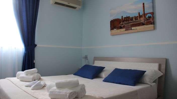 Ein Schlafzimmer mit einem Bett und einem Gemälde an der Wand