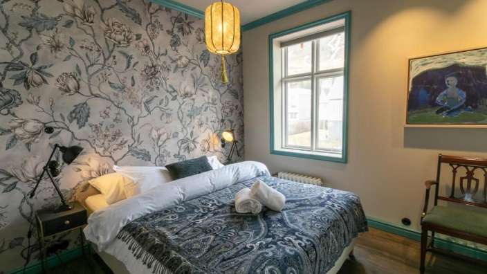 Ein Schlafzimmer mit einem Bett und einem Gemälde an der Wand