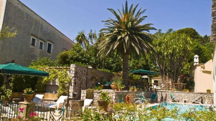 Ein großer Pool mit vielen Stühlen und Sonnenschirmen