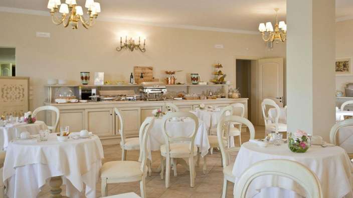 Ein Esszimmer mit vielen Tischen und Stühlen