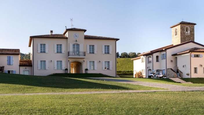 Ein großes Haus mit einem Uhrturm davor