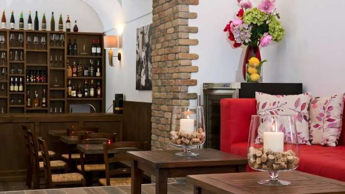 Ein Wohnzimmer mit einer roten Couch und einem Tisch mit Kerzen darin