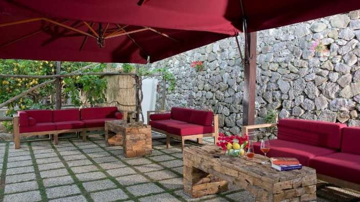 Eine Terrasse mit roten Möbeln und einem roten Regenschirm