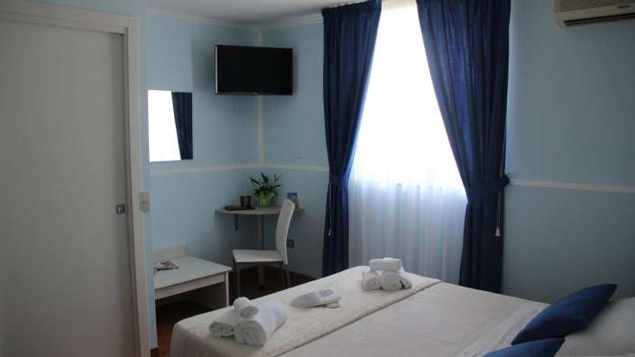 Ein Schlafzimmer mit einem Bett und einem Fernseher an der Wand