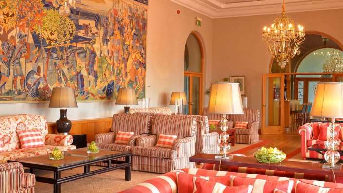 Ein Wohnzimmer mit vielen Möbeln und einem Gemälde an der Wand