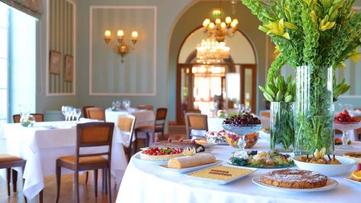 Ein Tisch mit verschiedenen Desserts und Blumen in einem Restaurant