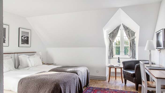 Ein Hotelzimmer mit zwei Betten und einem Stuhl