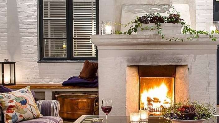 Ein Wohnzimmer mit einem Kamin und einem Glas Wein