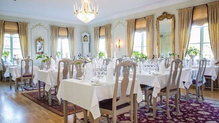Ein Esszimmer mit Tischen und Stühlen und einem Kronleuchter
