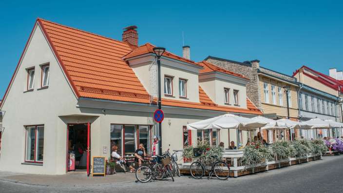 Eine Gruppe von Menschen sitzt an einem Tisch vor einem Gebäude