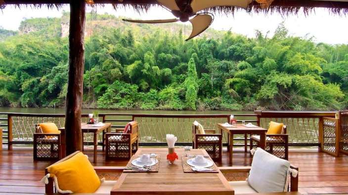 Ein Tisch und Stühle auf einem Deck mit Blick auf einen Fluss