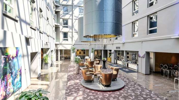 Ein Hotelflur mit vielen Stühlen und einem großen Kronleuchter